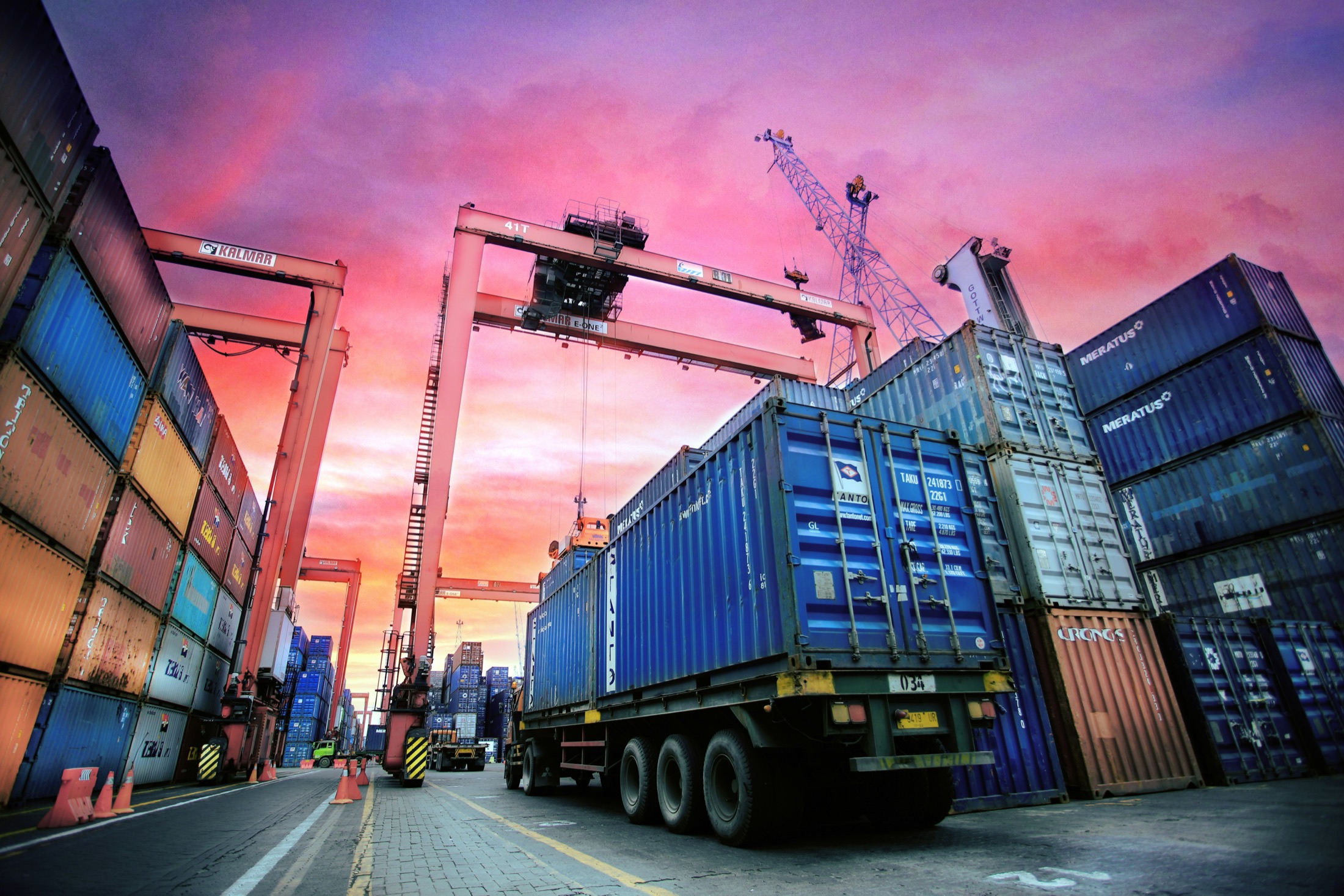 Truck picking up a container at a working port terminal